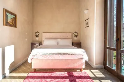 a bedroom with a bed with a pink bedspread and a rug at Conte Federico Apartments in Palermo