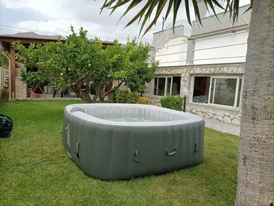 a hot tub in the grass in front of a house at Villa Giulia in Alcamo Marina