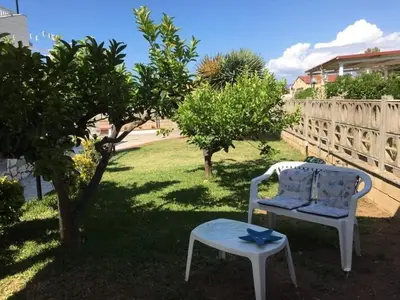 a white chair and a table in a yard at Villa Giulia in Alcamo Marina