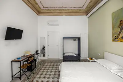 a bedroom with a bed and a tv on the wall at Palazzo Amazigh in Palermo