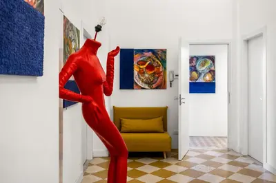 a red mannequin in a room with paintings at Palazzo Amazigh in Palermo
