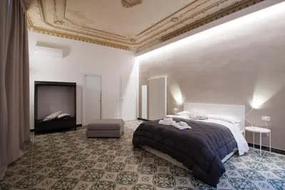 a bedroom with a large bed and a tv at Palazzo Amazigh in Palermo
