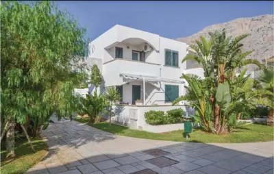 a white house with a mountain in the background at Appartamento Darling in Isola delle Femmine