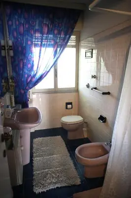 a bathroom with a sink and a toilet and a window at VILLA LEA in Mondello