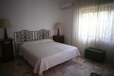 a bedroom with a bed and a large window at VILLA LEA in Mondello
