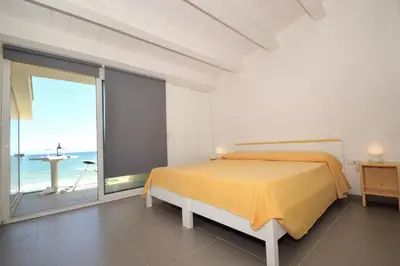 a white bedroom with a bed and a large window at La Dimora di Venere in Alcamo