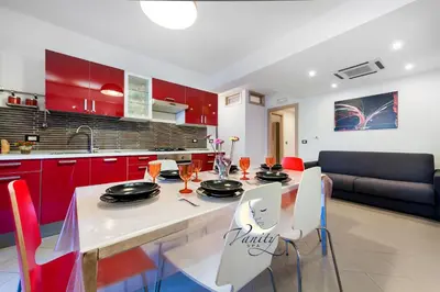 a kitchen with red cabinets and a table and chairs at Vanity SPA in Balestrate