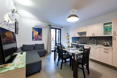 a kitchen and living room with a table and a couch at Vanity SPA in Balestrate