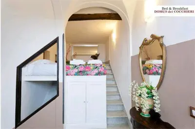 a room with a staircase with a mirror and flowers at B&B Domus Dei Cocchieri in Palermo