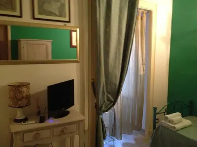 a bedroom with a bed and a television and a mirror at B&B Domus Dei Cocchieri in Palermo