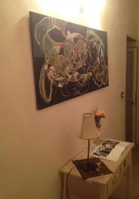 a table with a lamp and a painting on the wall at B&B Domus Dei Cocchieri in Palermo