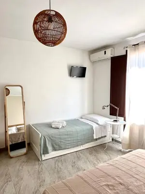 a bedroom with a bed and a mirror and a television at Casa Helios in Castellammare del Golfo
