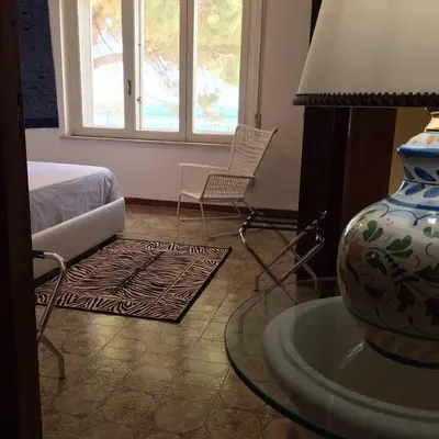 a room with a bed and a table with a lamp at Blue Island Villa Caterina in Casteldaccia