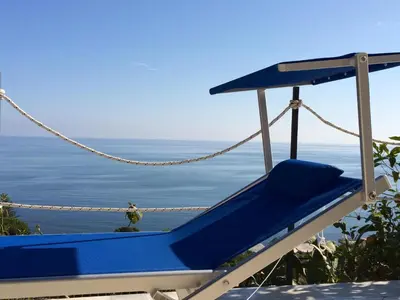 a blue chair sitting on the side of a beach at Blue Island Villa Caterina in Casteldaccia