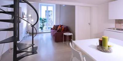 a kitchen and a living room with a table and a spiral staircase at SpasimoH-3 in Palermo