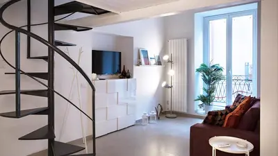 a living room with a spiral staircase and a couch at SpasimoH-3 in Palermo