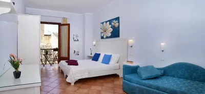 a living room with a couch and a blue chair at Badia Rooms & Breakfast in Castellammare del Golfo