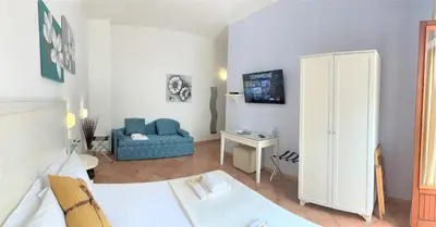 a living room with a bed and a blue couch at Badia Rooms & Breakfast in Castellammare del Golfo