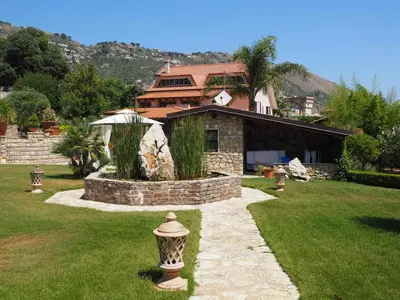 a house with a stone pathway in front of a yard at B&B Al Giardino in Monreale