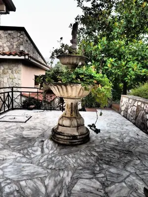 a large stone fountain sitting on a stone patio at B&B Al Giardino in Monreale
