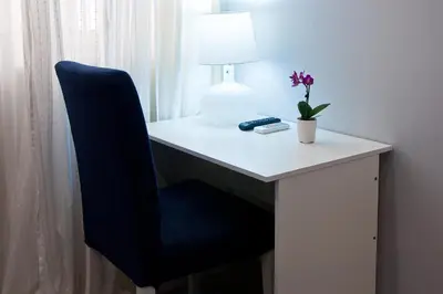 a desk with a chair and a lamp and a flower at Operà in Palermo