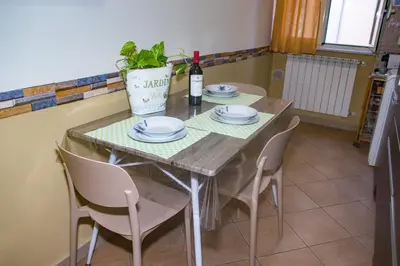 a dining room table with a plant and a bottle of wine at Casa Primavera in Palermo