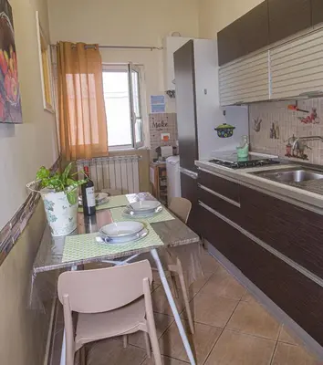a kitchen with a table with chairs and a sink at Casa Primavera in Palermo