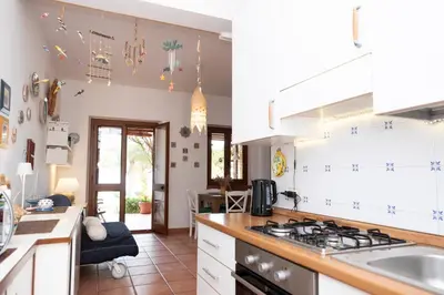 a kitchen with white cabinets and a stove top oven at Casa Ponente con Vista Mare a Macari in Macari