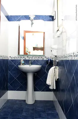 a blue and white bathroom with a sink and a mirror at Donna Lia in Bagheria