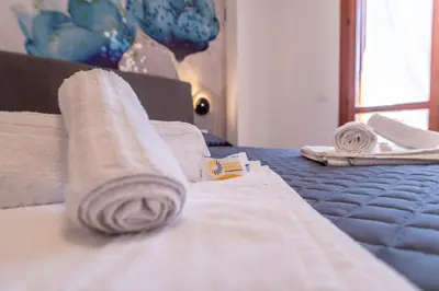 a bed with a rolled up towel on it at Residence Marinella in San Vito lo Capo