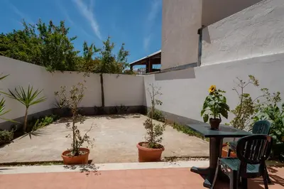 a patio with a table and potted plants at Residence Marinella in San Vito lo Capo