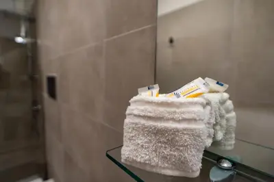 a glass table in a bathroom with towels on it at Residence Marinella in San Vito lo Capo