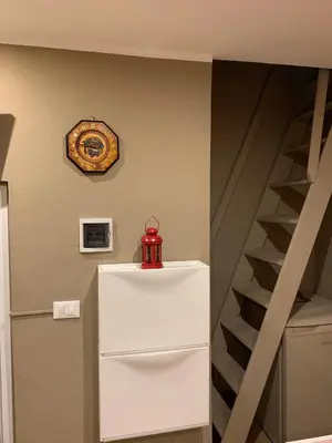 a refrigerator with a clock on the wall and a staircase at Casa Rosina in Palermo