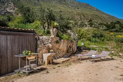 a yard with two chairs and a table and a fence at Villa Elena vicino la Riserva naturale dello Zingaro in Scopello