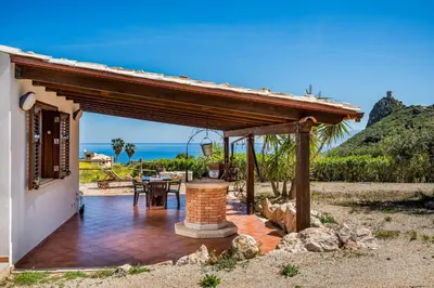a patio with a wooden pergola next to a house at Villa Elena vicino la Riserva naturale dello Zingaro in Scopello