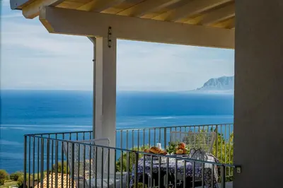 a table with food on it with a view of the ocean at Villa Rosaria vicino la Riserva dello Zingaro in Scopello