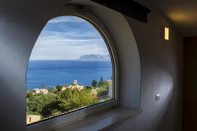 a kitchen with a table and chairs and a window at Villa Rosaria vicino la Riserva dello Zingaro in Scopello