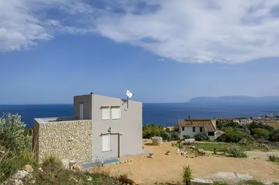 a balcony with a table with a view of the ocean at Villa Rosaria vicino la Riserva dello Zingaro in Scopello