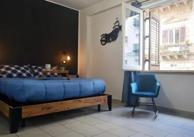 a bedroom with a blue bed and a blue chair at Casa in centro in Palermo