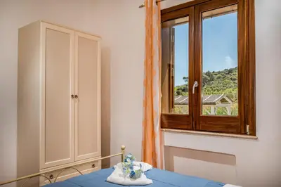 a room with a window and a table with a blue table at APT Villa Anna e APT Cantina Vito vicinissimi alla Riserva dello Zingaro in Scopello