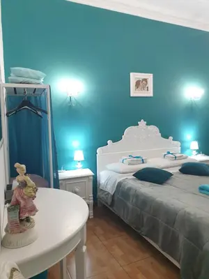 a blue bedroom with two beds and a white table at Affitta Camere Al Castello in Palermo