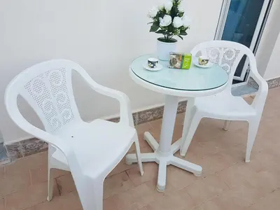 two white chairs and a glass table and chairs at Affitta Camere Al Castello in Palermo