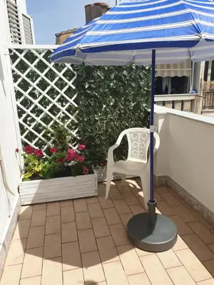 a blue umbrella and a white chair on a balcony at Affitta Camere Al Castello in Palermo