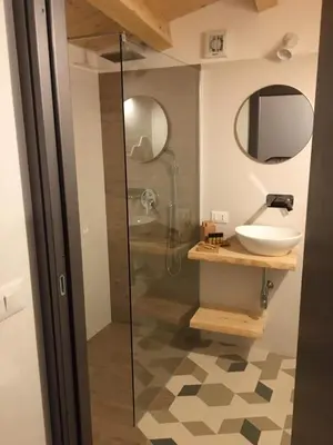 a bathroom with a glass shower and a sink at Torre's Camere & caffè in Monreale