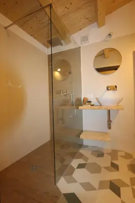 a bathroom with a glass shower and a sink at Torre's Camere & caffè in Monreale