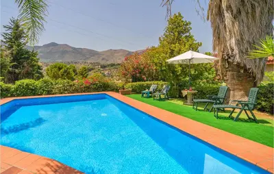 a swimming pool in a yard with chairs and an umbrella at Awesome Home In Trabia With Wifi in Trabia