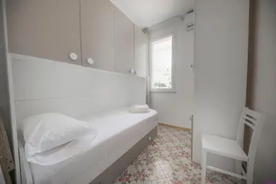 a white bedroom with a bed and a window at Appartamento 8 Pax in Villa Francesca by Ville in Palermo in Casteldaccia