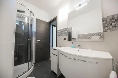 a white bathroom with a sink and a shower at Appartamento 16 Pax in Villa Francesca by Ville in Palermo in Casteldaccia