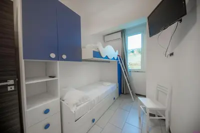 a small bedroom with a bed and a blue cabinet at Appartamento 23 Pax in Villa Francesca by Ville in Palermo in Casteldaccia