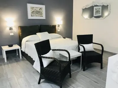 a bedroom with a bed and two chairs at Home 3L in Palermo